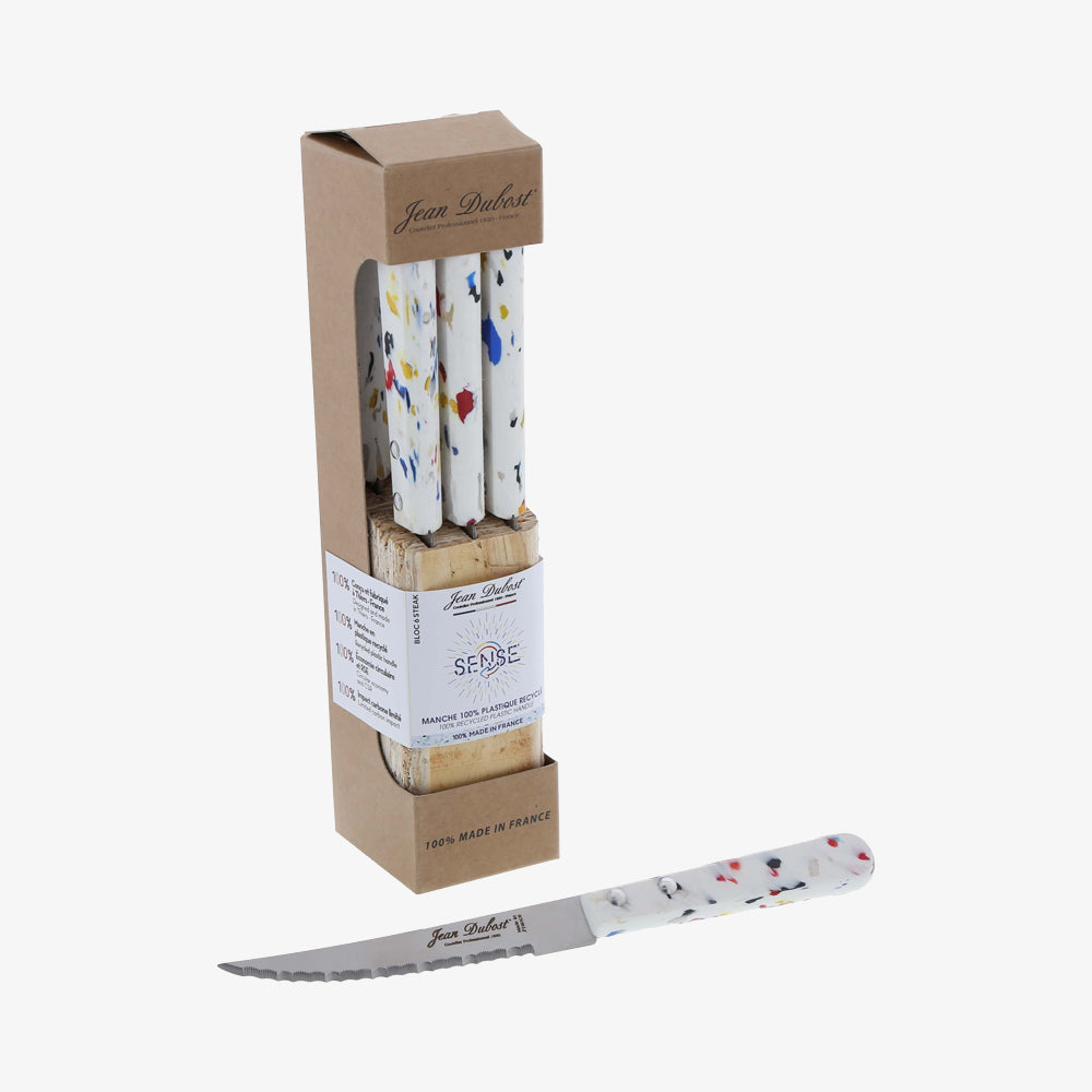 Jean Dubost steak knive sæt med hvidt håndtag og farvede detaljer, præsenteret i gjenbrugelig plastik emballage.